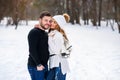 Beautiful couple in love hugging each other while walking in a winter Park.