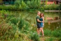 A beautiful couple in love, a man and a woman, embrace on the shore of a summer lake. Amazing natural landscape Royalty Free Stock Photo