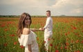 beautiful couple in love. man and woman in poppy flower field. summer vacation. happy family among red flowers. spring Royalty Free Stock Photo