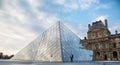 Beautiful couple in love near building of Louvre Museum in Paris