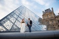 Beautiful couple in love near building of Louvre Museum in Paris