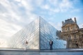 Beautiful couple in love near building of Louvre Museum in Paris