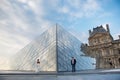 Beautiful couple in love near building of Louvre Museum in Paris