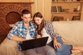 Beautiful couple in love sitting on the sofa with laptop Royalty Free Stock Photo