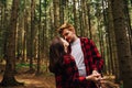 Beautiful couple in love young men in red shirts standing in a coniferous forest and hugging looking at each other. Couple Royalty Free Stock Photo