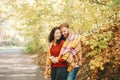 Beautiful couple man woman in love. Smiling laughing boyfriend and girlfriend wrapped in yellow blanket hugging in a park on
