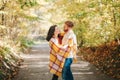 Beautiful couple man woman in love. Smiling laughing boyfriend and girlfriend wrapped in yellow blanket hugging in a park on