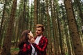 Beautiful couple of man and woman in red shirts hugging in the woods and looking at each other in love. Love story photo Royalty Free Stock Photo