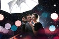 Beautiful couple man with woman with white umbrella in flash lights and rain drops
