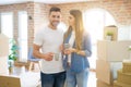 Beautiful couple moving to a new house, smiling cheerful drinking a cup of coffee Royalty Free Stock Photo