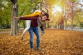 Beautiful couple piggy back in autumn