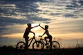 Beautiful couple posing with bicycles in sunset.