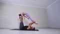 Beautiful couple practicing acro yoga. Young yoga instructors practice in a studio. Two successful young people perform Royalty Free Stock Photo