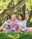 Beautiful couple sharing a slice of watermelon in the park while having a picnic. Royalty Free Stock Photo