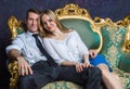 Beautiful couple sitting on classic sofa. Girl and boy on green sofa. Happy married couple. Successful people in vintage interior Royalty Free Stock Photo