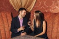 Beautiful couple sitting in a fancy restaurant and talking Royalty Free Stock Photo