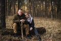 Beautiful couple sitting in the forest tired after hike and totally in love