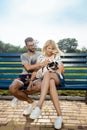 Beautiful couple sitting with French bulldog on bench in park. Royalty Free Stock Photo