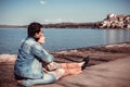 Beautiful couple sitting on the shore of Lake Bracciano. Royalty Free Stock Photo