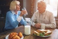 Beautiful couple are sitting at the table in the kitchen and dri