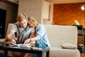 Couple students studying, reading book while sitting on sofa Royalty Free Stock Photo