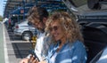 Beautiful couple of tourists in the parking of the airport looking at smart phone while waiting for the boarding of the flight