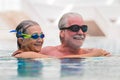 Beautiful couple of two seniors together at the swimming pool having fun - woman hugged at her husband smiling with love Royalty Free Stock Photo