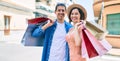 Beautiful couple on vacation smiling happy holding shopping bags at street of city Royalty Free Stock Photo
