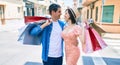 Beautiful couple on vacation smiling happy holding shopping bags at street of city Royalty Free Stock Photo