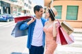 Beautiful couple on vacation smiling happy holding shopping bags at street of city Royalty Free Stock Photo