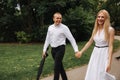 Beautiful couple walk in the park. Blonde hair man and woman spend time togerther. They take black umbrella. Background Royalty Free Stock Photo