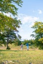 Beautiful couple walking with backpacks on the green meadow, while traveling high in the mountains during the summer