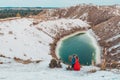 Beautiful couple walking in the phosphate-gypsum white mountains of Ukraine, the girl in a red dress on a background of a green