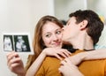 Beautiful couple watching with emotion ultrasound pictures of th