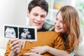 Beautiful couple watching with emotion ultrasound pictures of their baby