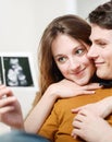 Beautiful couple watching with emotion ultrasound pictures of their baby