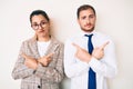 Beautiful couple wearing business clothes pointing to both sides with fingers, different direction disagree