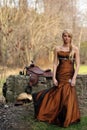 Beautiful cowgirl in a formal dress near a cement wall Royalty Free Stock Photo