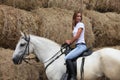 Beautiful cowgirl posing with white horse in the ranch Royalty Free Stock Photo