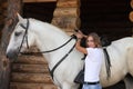 Beautiful cowgirl posing with white horse in the ranch Royalty Free Stock Photo