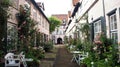 Beautiful cozy courtyard with white benches, plants and flowers in the street of old town, Lubeck, Germany Royalty Free Stock Photo