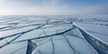 Beautiful cracked ice surface with varying shades of blue in a serene winter setting. Royalty Free Stock Photo