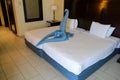 beautiful crane, a swan, a bird made of a blue towel on a large bed in a hotel in the resort Royalty Free Stock Photo