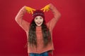 Beautiful crazy. Crazy child show horns on head. Happy girl with crazy look red background. Crazy holiday mood. Winter