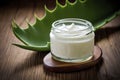 Beautiful cream bottle with beauty products aloe green leaves on wood background. Natural organic skin care