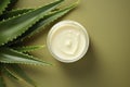 Beautiful cream bottle with beauty products aloe leaves on green background. Natural organic skin care