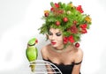 Beautiful creative Xmas makeup and hair style indoor shot. Beauty Fashion Model Girl with green parrot Royalty Free Stock Photo