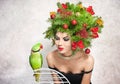 Beautiful creative Xmas makeup and hair style indoor shot. Beauty Fashion Model Girl with green parrot Royalty Free Stock Photo