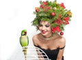 Beautiful creative Xmas makeup and hair style indoor shot. Beauty Fashion Model Girl with green parrot Royalty Free Stock Photo