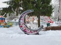 Beautiful crescent moon bench with flowers and lamps inside in the children's city park